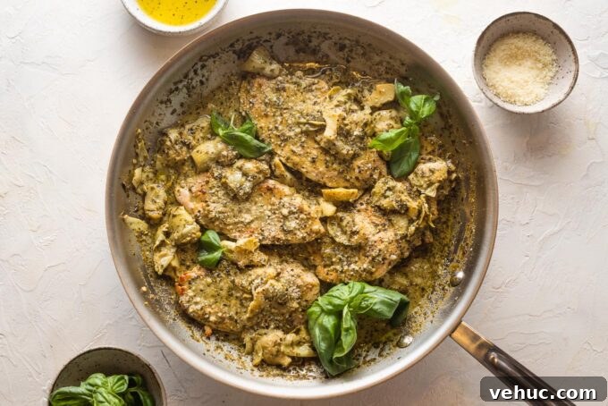 Pesto Chicken with Roasted Artichokes Recipe 8 Pesto artichoke chicken skillet garnished with fresh basil and grated Parmesan cheese.