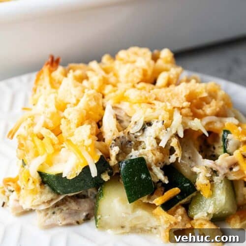 sideview of serving of keto and low carb chicken and zucchini casserole on a white plate