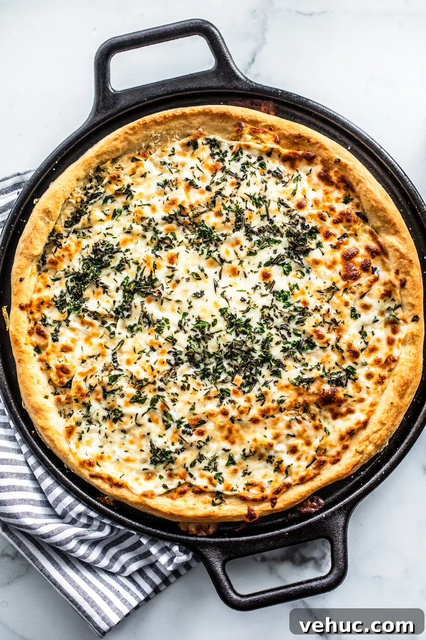 Herb & Garlic Cheese Pizza Recipe for Crispy, Flavorful Homemade Slices 2 Overhead shot of cooked herb and garlic cheese pizza in cast iron pizza pan.