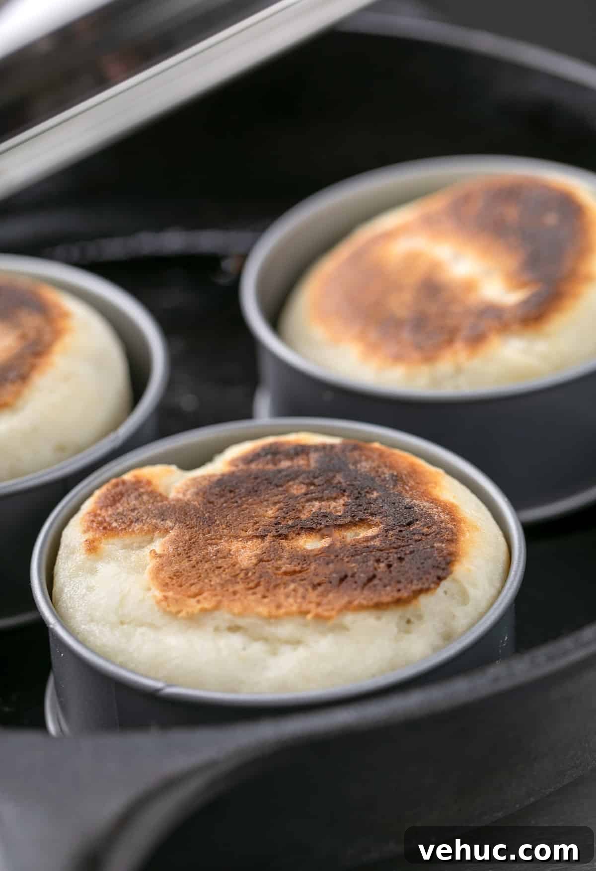 3 English muffins in rings in a round cast iron skillet