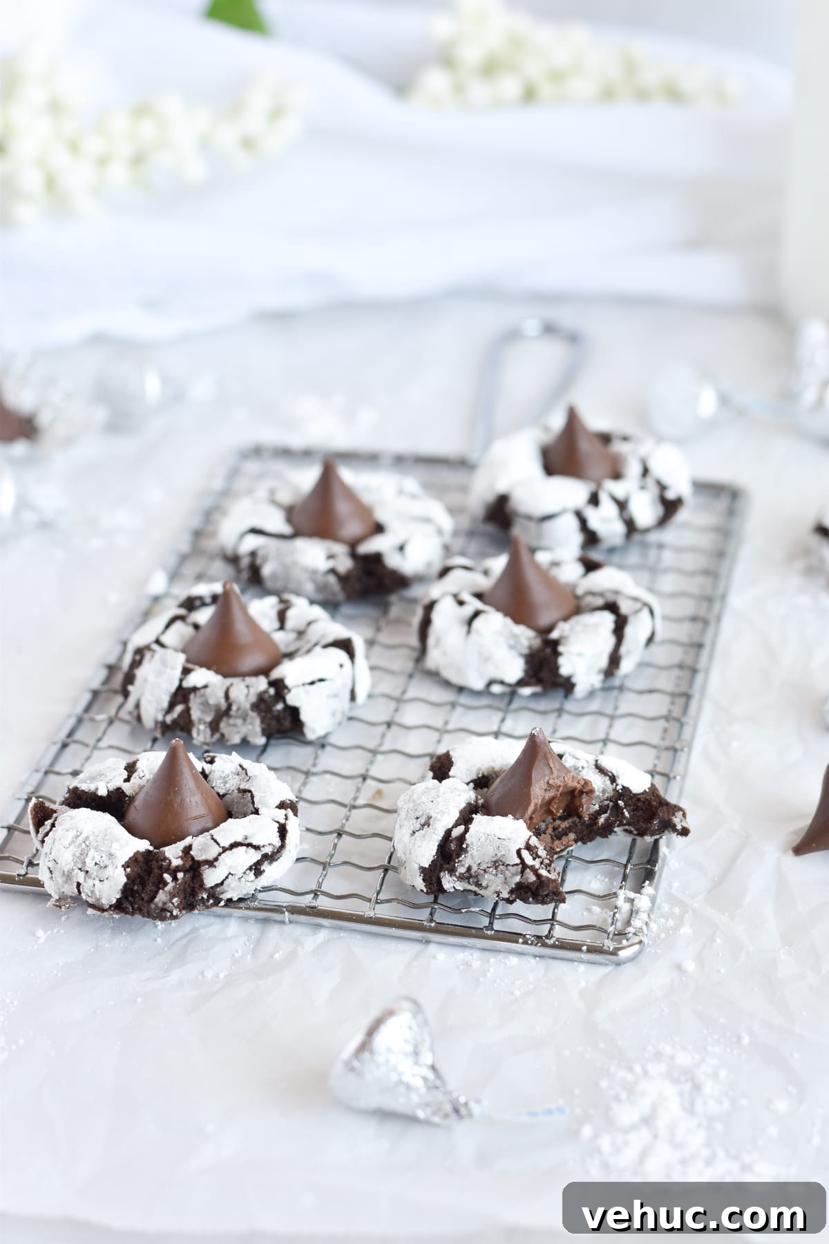 Cocoa Blossom Cookies Recipe: Soft Chocolate Flower Cookies 8 chocolate cookies on small wire cooling rack, one with a bite out of it.
