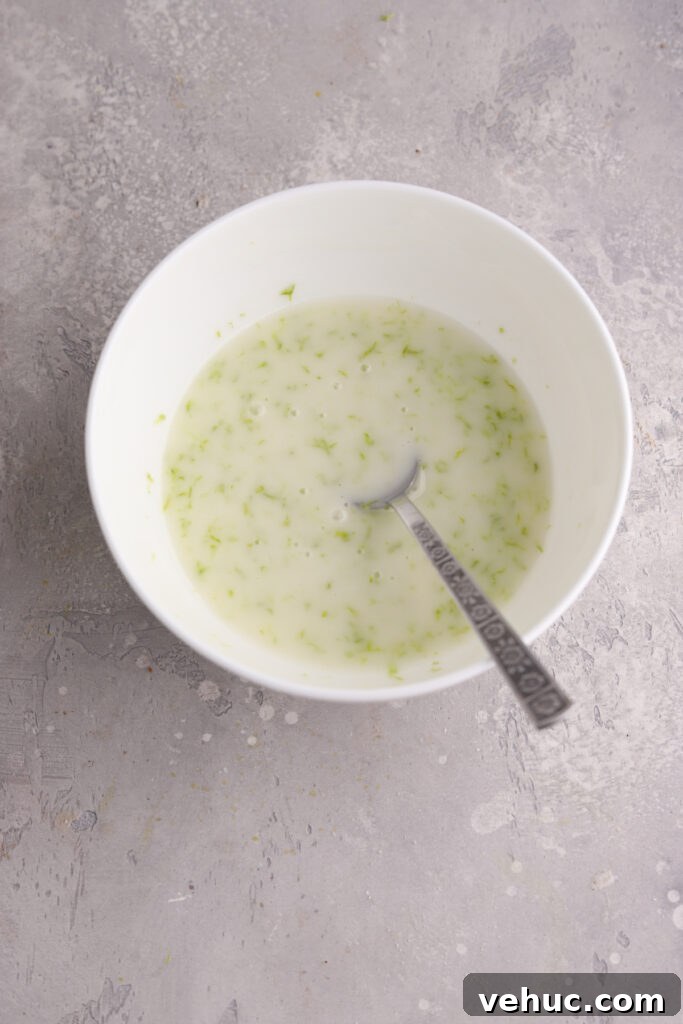 A white bowl with lime glaze and a spoon.