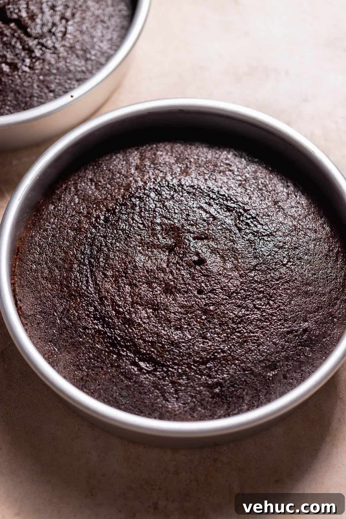 Moist Chocolate Cake Recipe That Tops Bakery Cakes 5 Two round chocolate cake layers baked in metal pans with a smooth, even surface.