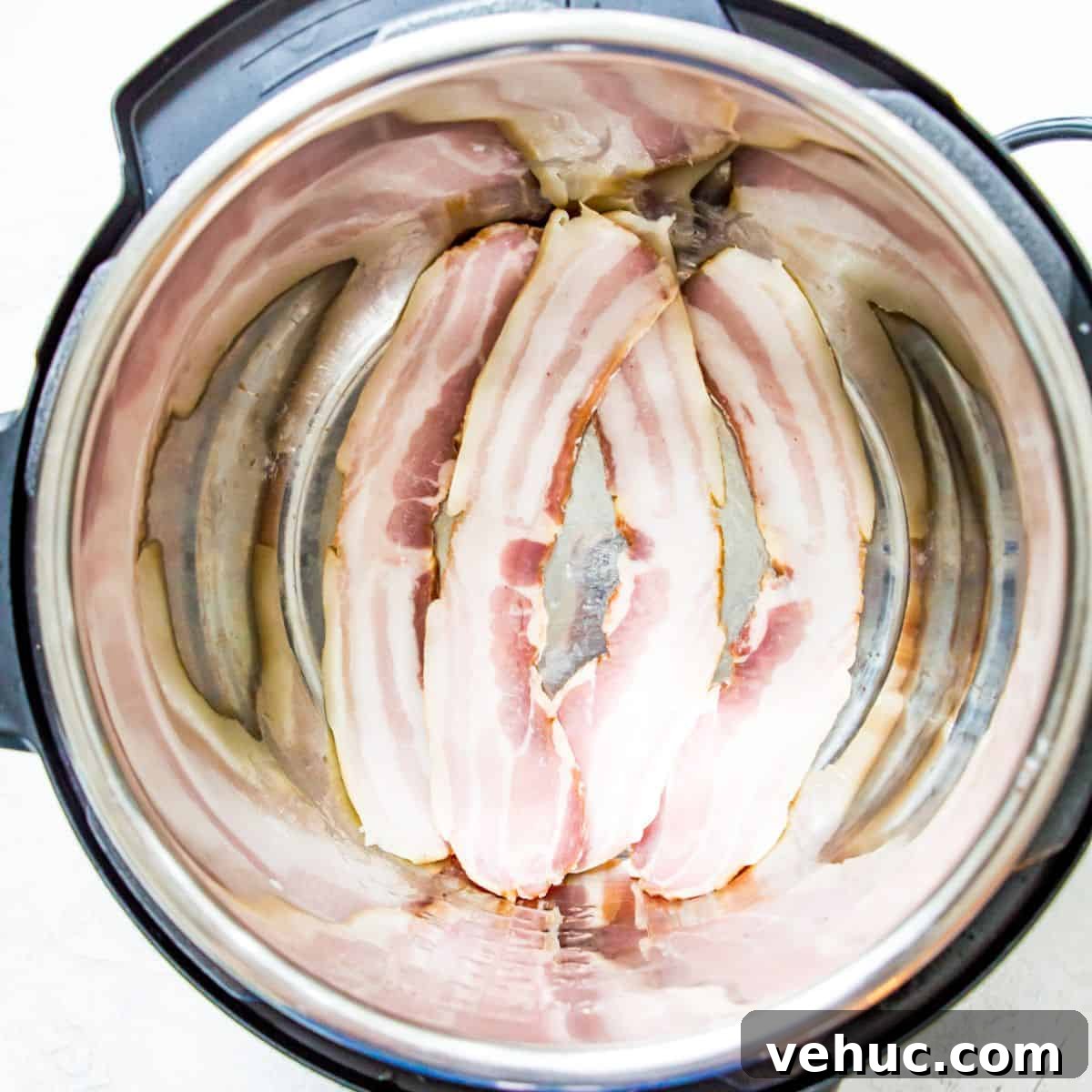 Crispy Instant Pot Bacon in Minutes: Tender, Savory Results 3 An Instant Pot with uncooked bacon strips in it.