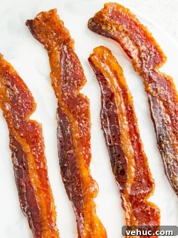 Four pieces of bacon jerky on a plate.