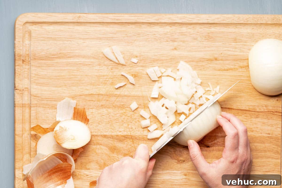Roasted Turkey and Sweet Potato Soup Recipe 4 chopping onion on wooden cutting board