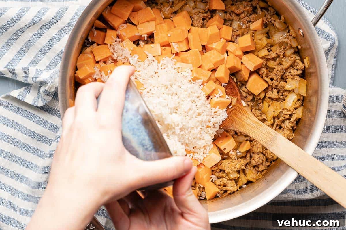 Roasted Turkey and Sweet Potato Soup Recipe 8 rice being poured into soup pot with sweet potatoes and turkey
