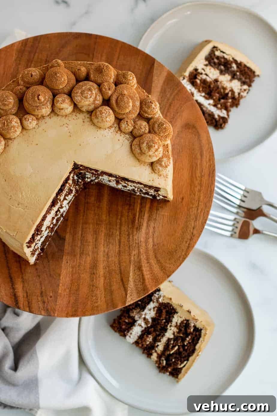 Decadent Chocolate Mocha Cake Recipe with Espresso Frosting 2 chocolate mocha cake on a wood cake stand with 2 slices of cake on plates
