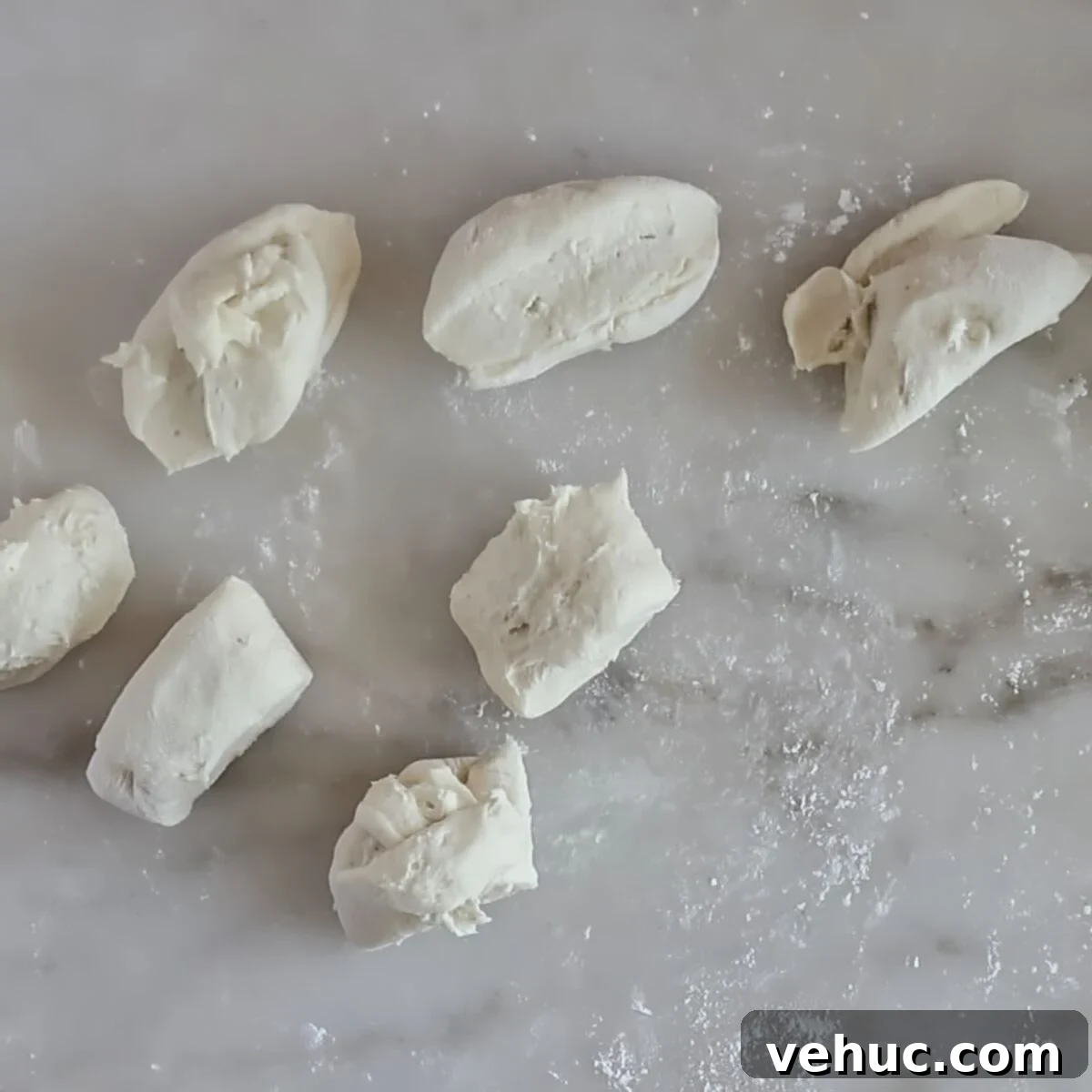 Gluten-Free Sourdough English Muffins Recipe You’ll Love 6 dough divided into small pieces on marble surface.