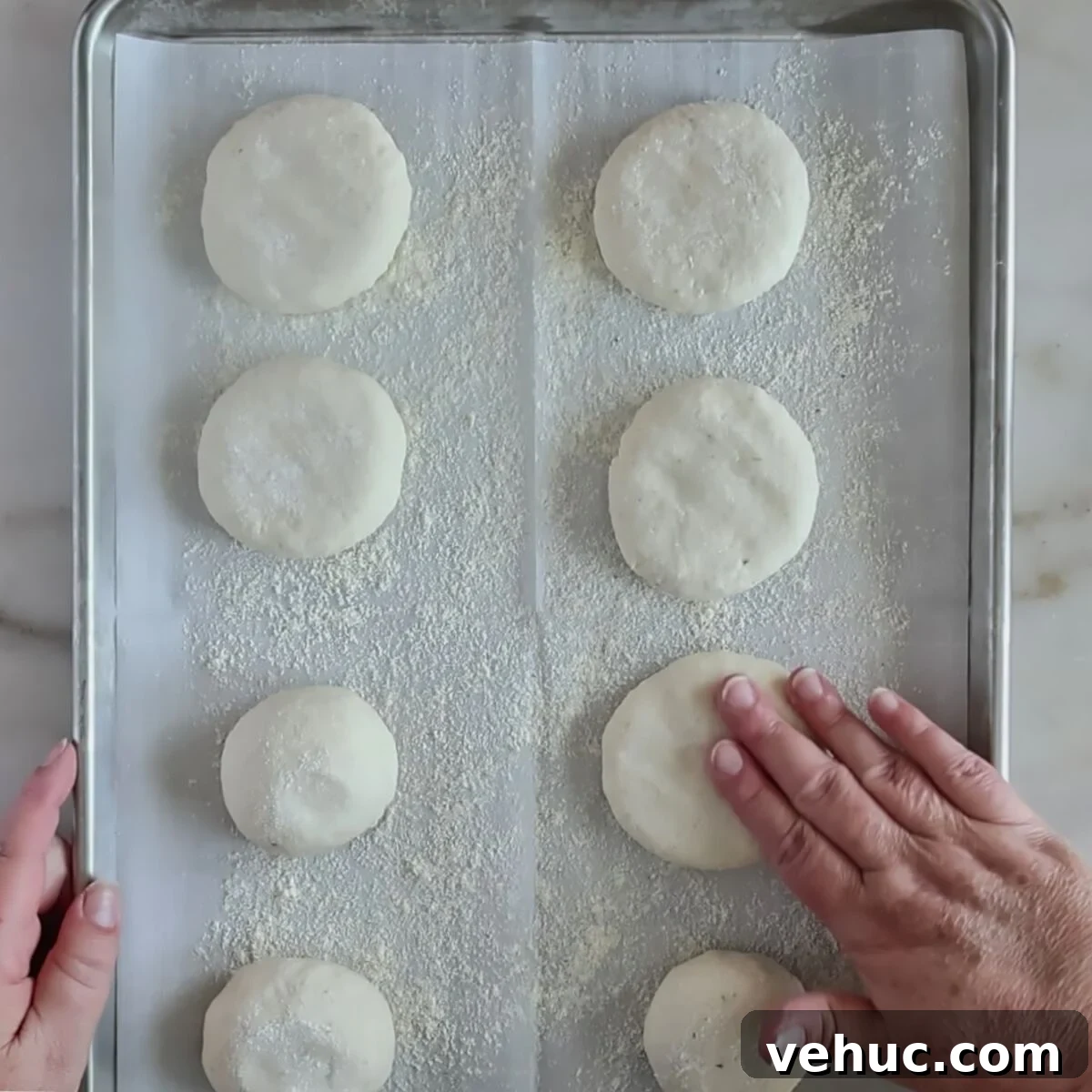 Gluten-Free Sourdough English Muffins Recipe You’ll Love 9 flattening round rolls on baking sheet.
