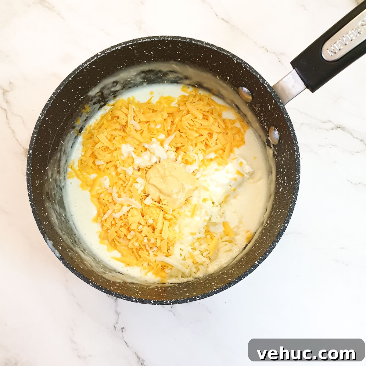 Ultimate Creamy Macaroni & Cheese Recipe for Comfort Night 7 Grated cheese being added to the sauce in a saucepan.