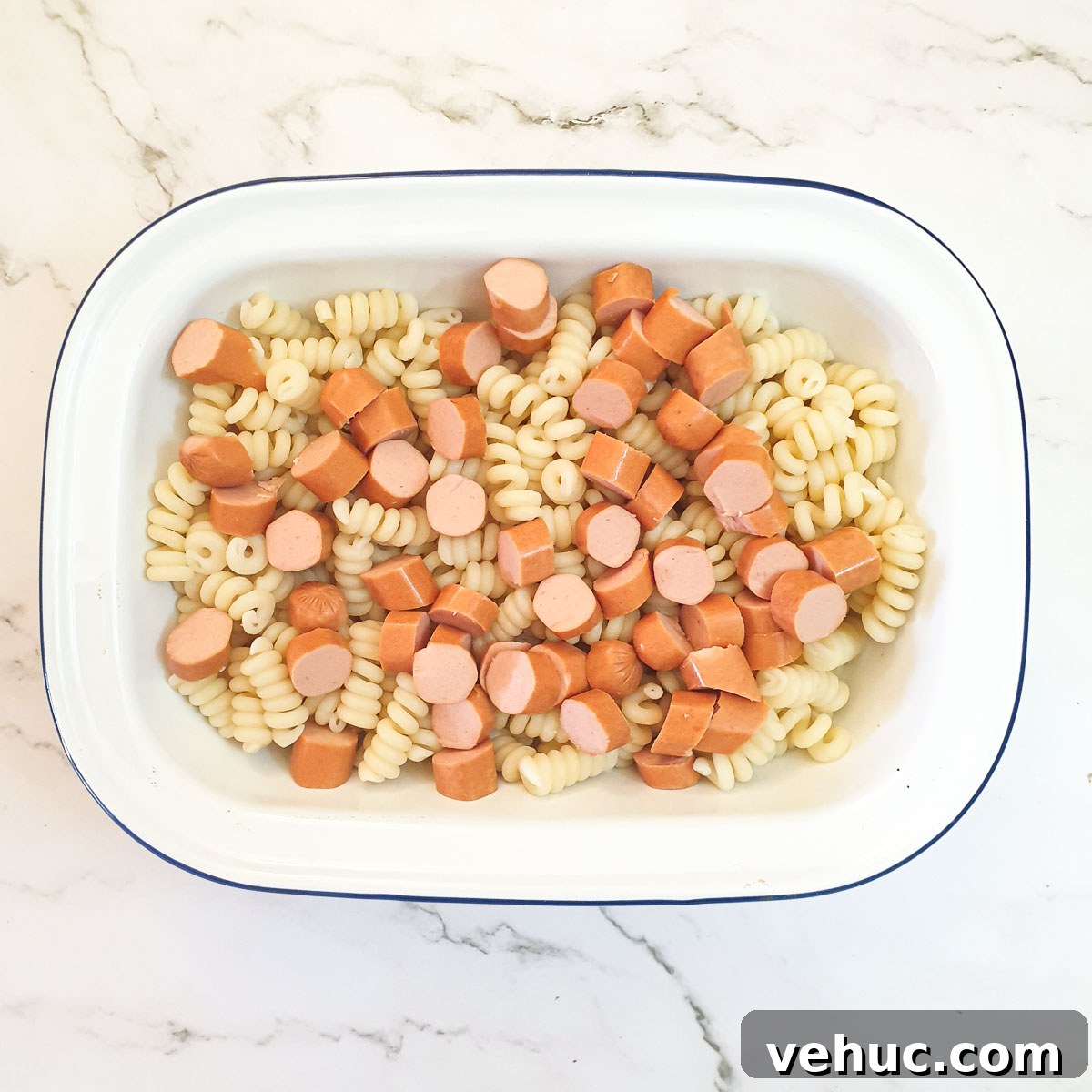 Ultimate Creamy Macaroni & Cheese Recipe for Comfort Night 9 Pasta and chopped sausages in a baking dish.