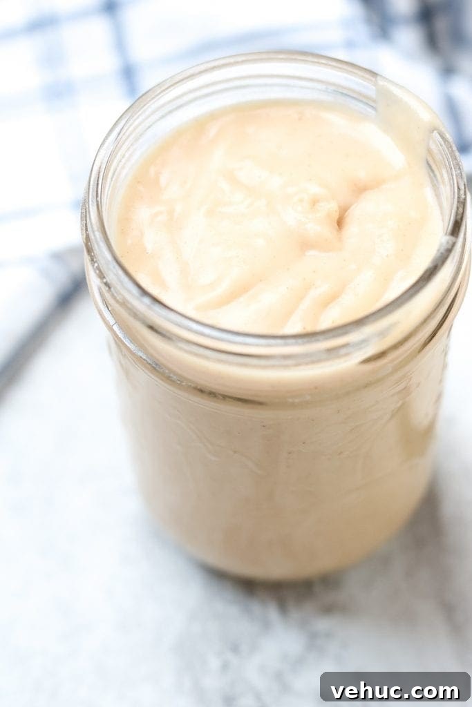 Homemade Cream of Chicken Soup Clear glass jar filled with thick condensed cream of chicken soup from scratch.