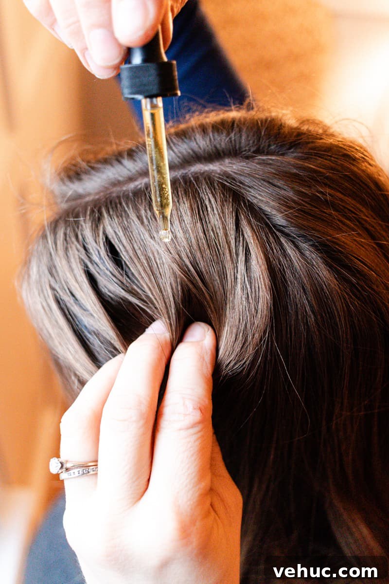 DIY Hair Growth Oil for Thicker, Fuller Hair in Weeks 2 Applying a few drops of hair growth oil to my hair.