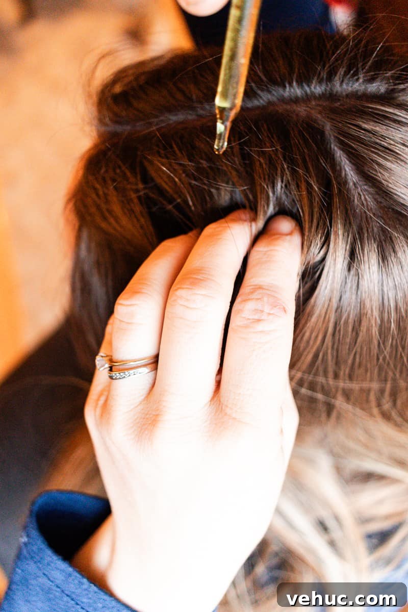 DIY Hair Growth Oil for Thicker, Fuller Hair in Weeks 6 Using a dropper to apply the homemade hair growth oil to my hair.