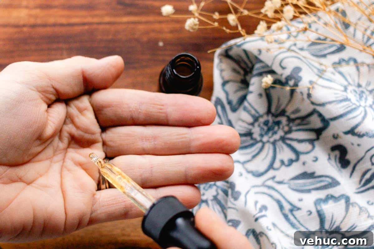 DIY Hair Growth Oil for Thicker, Fuller Hair in Weeks 9 Warming a few drops of hair growth oil with jojoba oil and rosemary oil in the palm of my hand.
