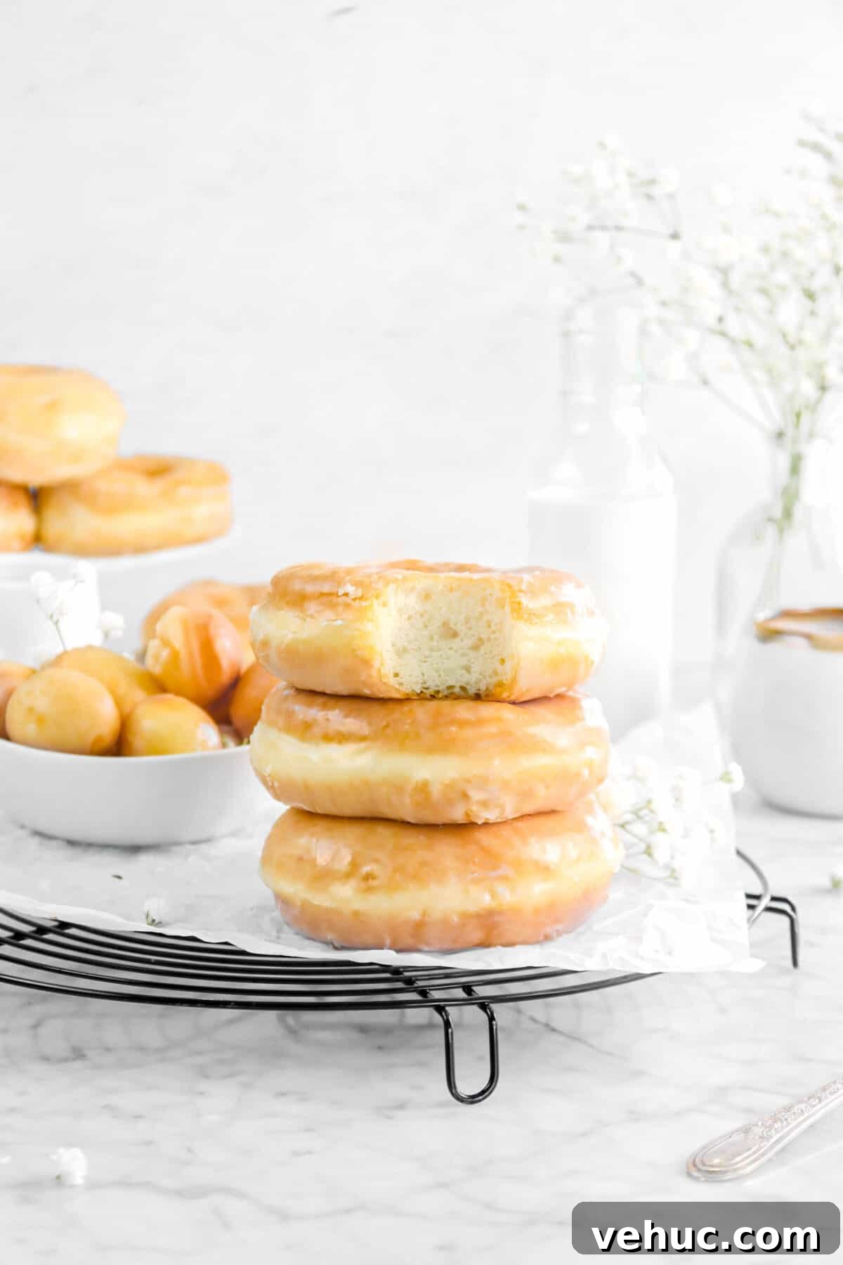 Top 21 Most-Loved Recipes of 2021: Trending Dishes You’ll Want to Try 2 three doughnuts stacked with a bite taken out of one, flowers, milk, and more doughnuts behind