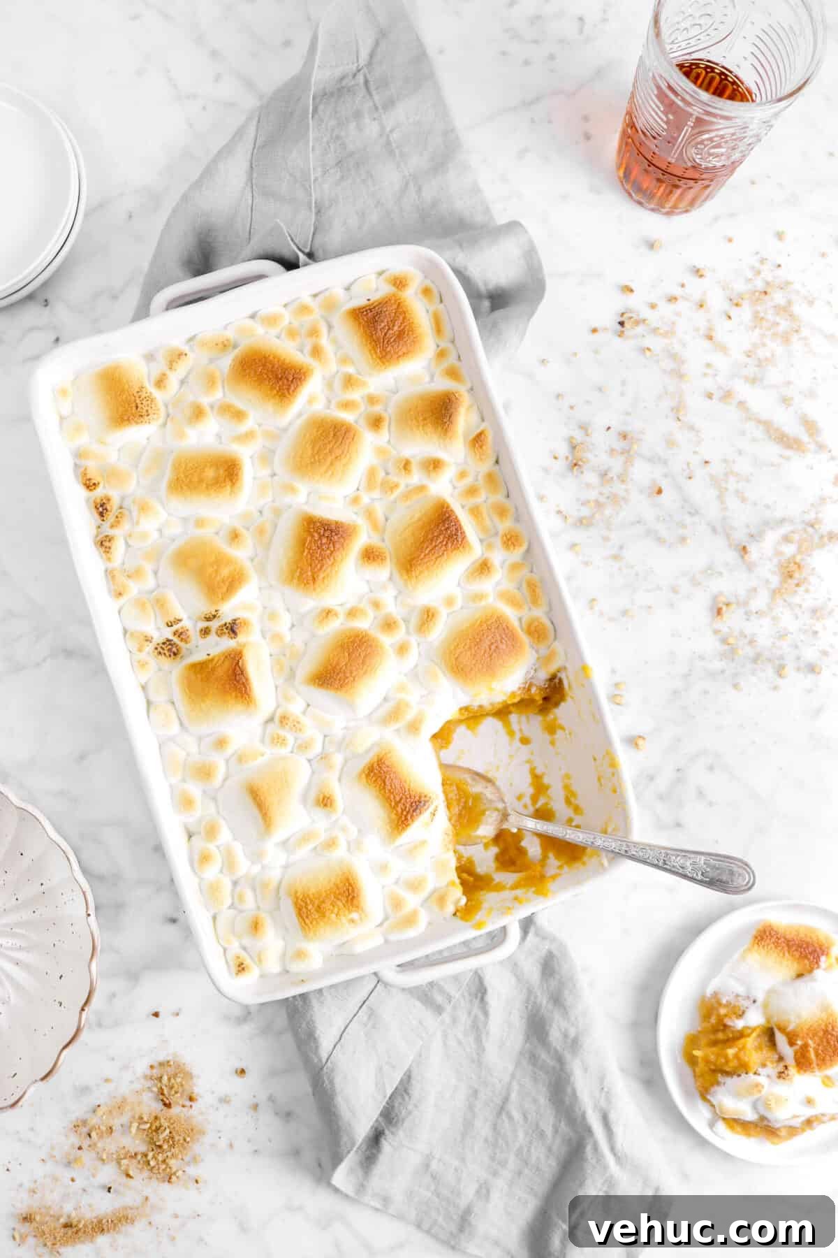 Top 21 Most-Loved Recipes of 2021: Trending Dishes You’ll Want to Try 11 overhead shot of sweet potato casserole with roasted marshmallows on a grey napkin with some on a plate and glass of bourbon