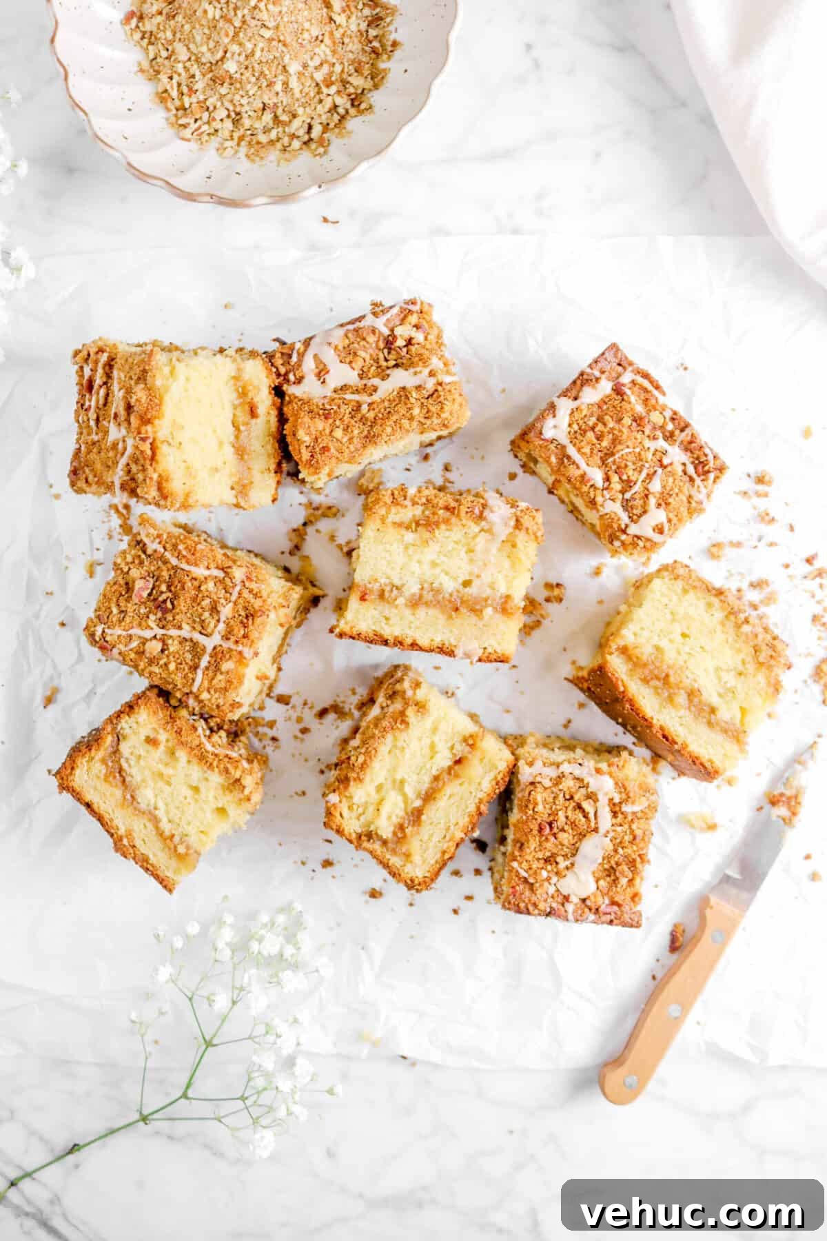 Top 21 Most-Loved Recipes of 2021: Trending Dishes You’ll Want to Try 17 nine slices of apple pie coffee cake on parchment with streusel, a knife, and flowers