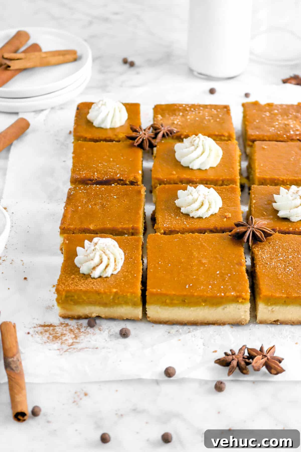 Top 21 Most-Loved Recipes of 2021: Trending Dishes You’ll Want to Try 18 twelve pumpkin pie bars on parchment paper with whole spices, plates, and milk glass