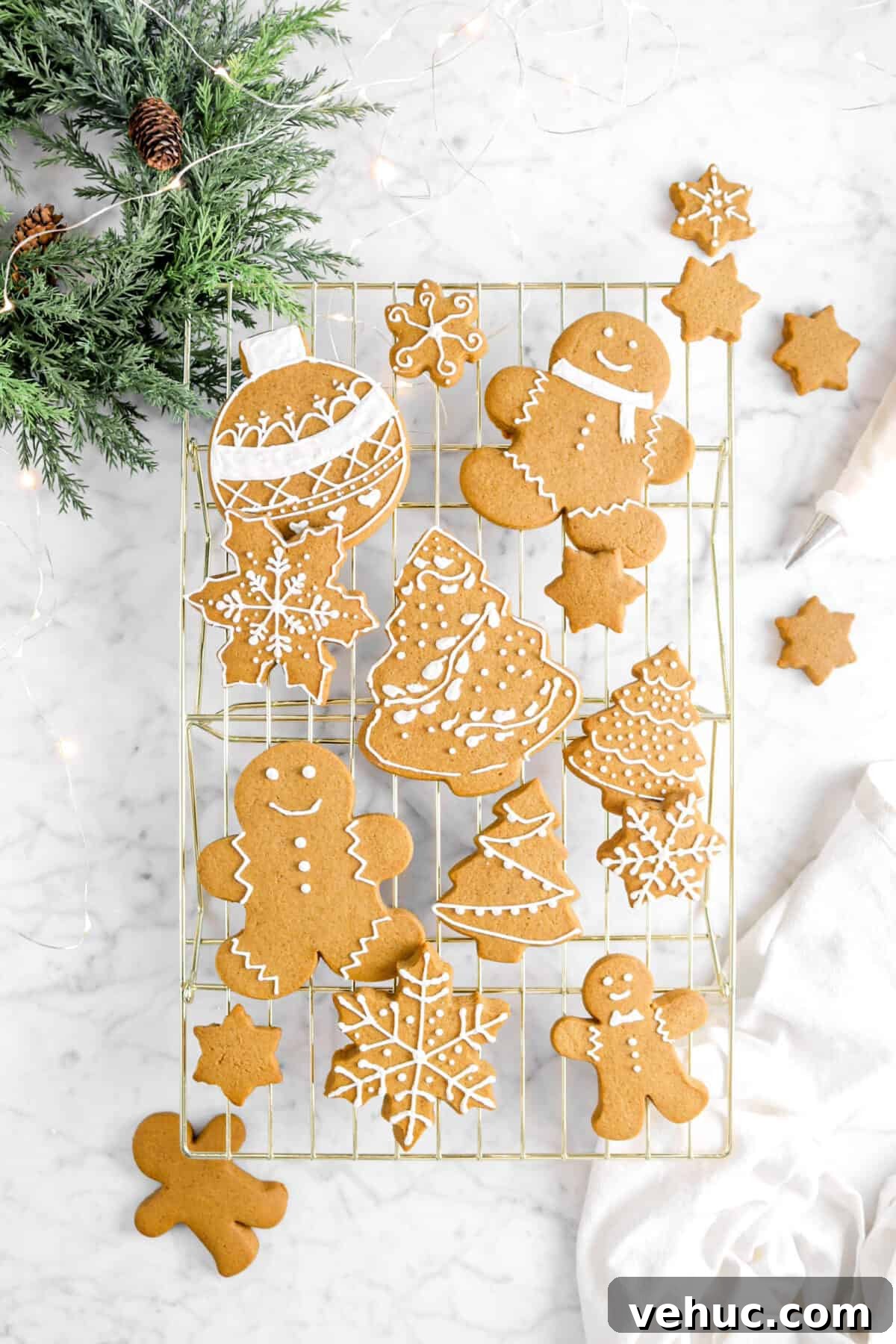 Top 21 Most-Loved Recipes of 2021: Trending Dishes You’ll Want to Try 5 iced gingerbread cookies on gold cooling rack with napkin, greenery, lights, and piping bag