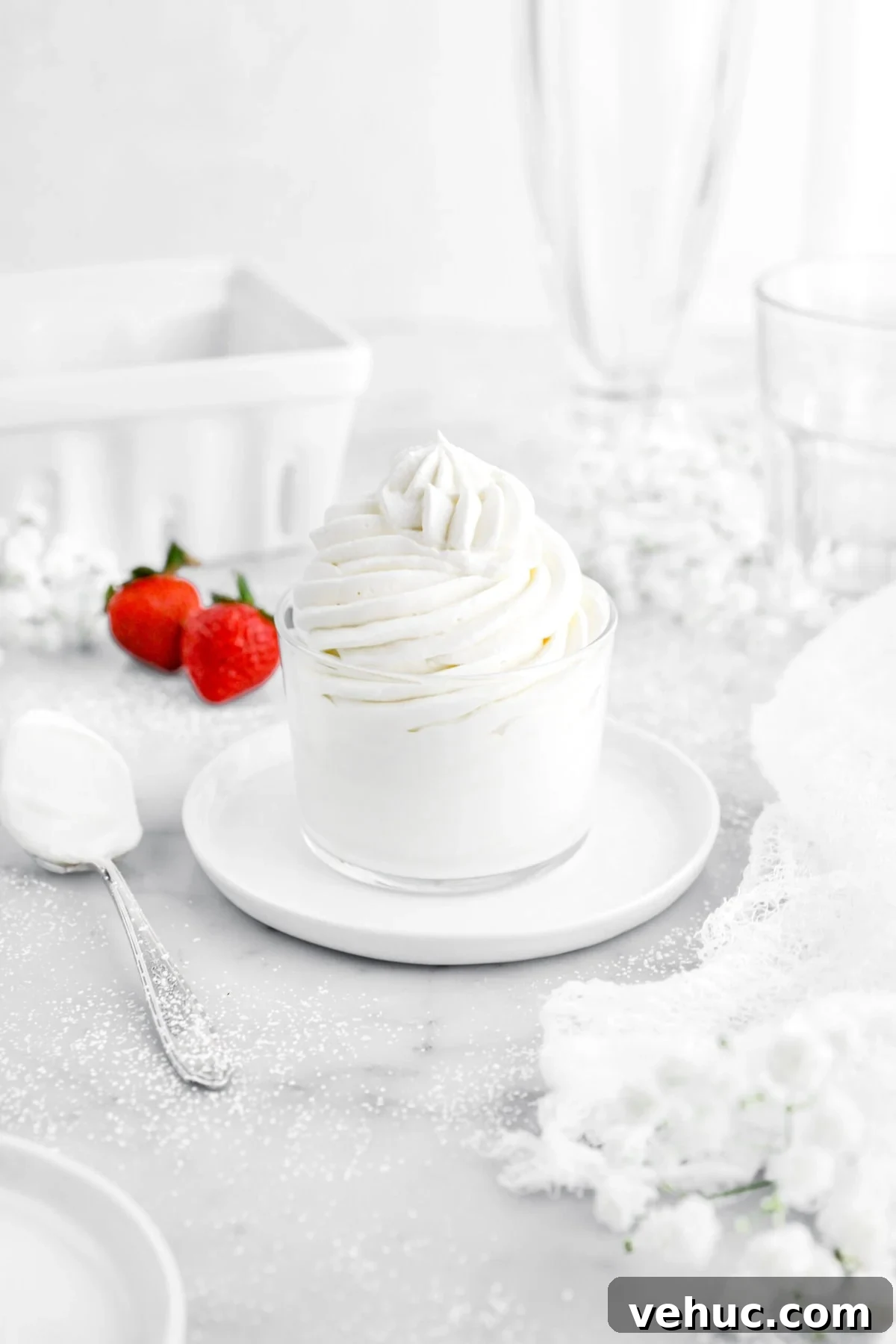 Top 21 Most-Loved Recipes of 2021: Trending Dishes You’ll Want to Try 9 angled image of piped chantilly cream in small glass on top of white plate with spoon beside and two strawberries behind.