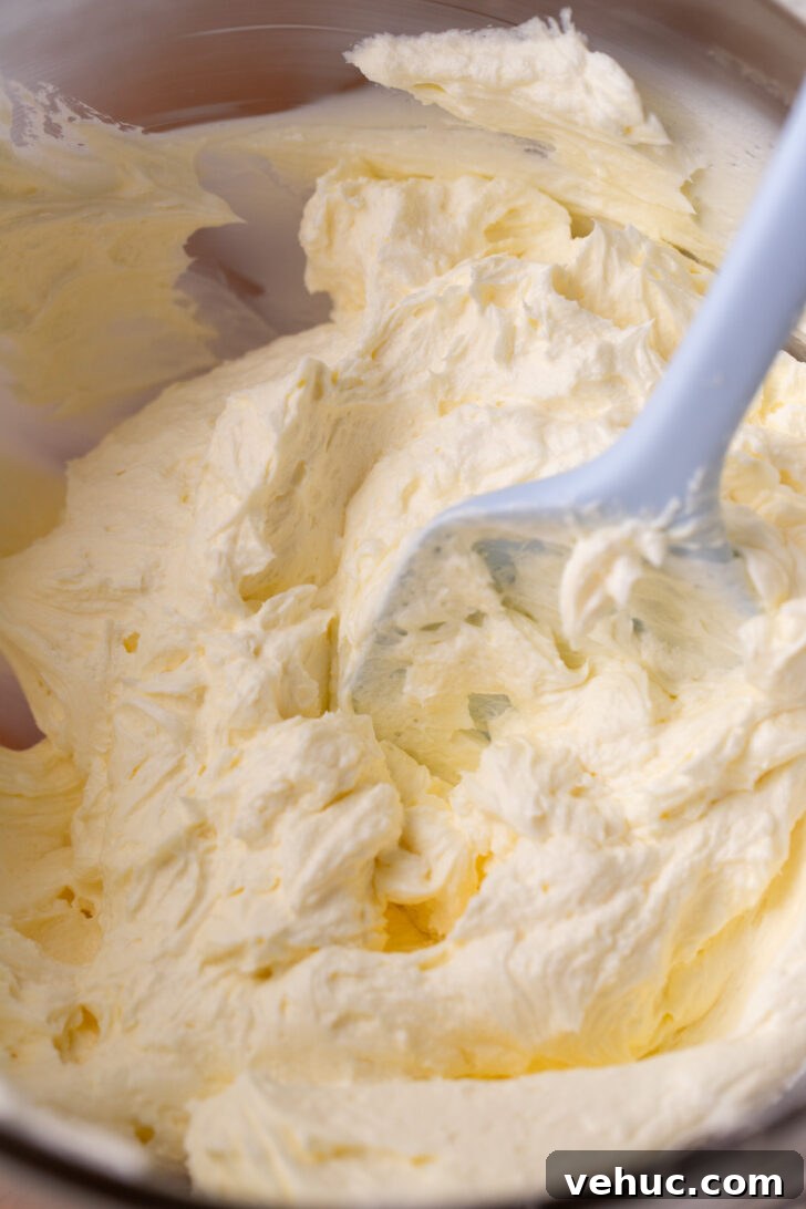 Silky Chocolate Cream Cheese Frosting Recipe for Cakes & Cupcakes 5 Whipped butter and cream cheese in a glass bowl.