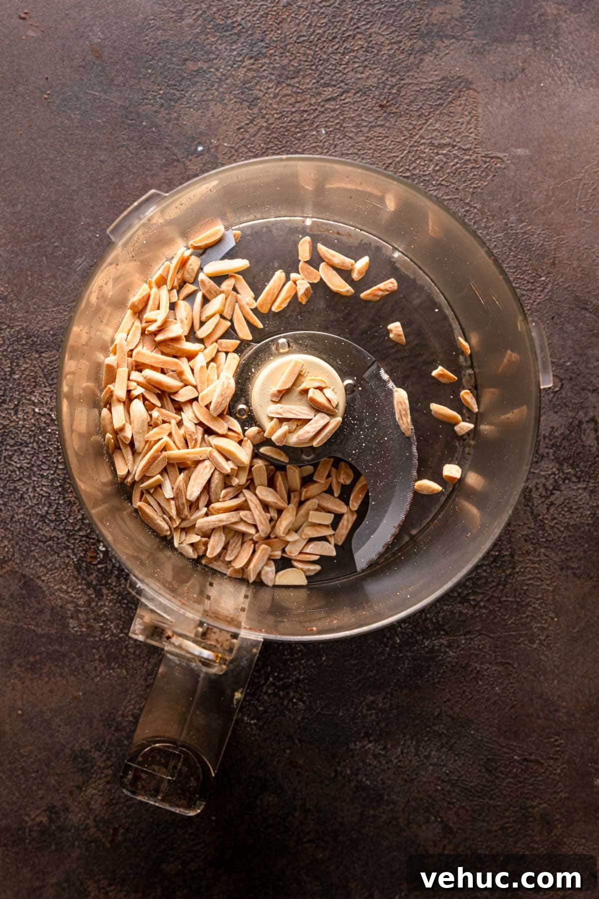 A food processor bowl with almonds.