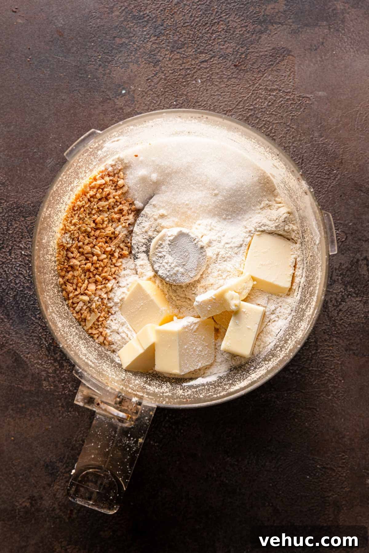 A food processor bowl with ground almonds, sugar, butter and flour.