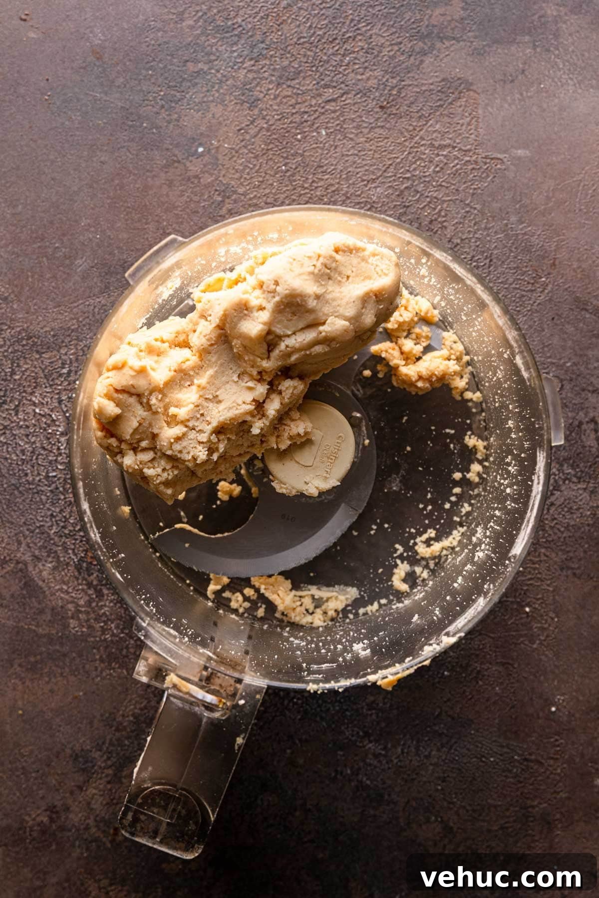 A food processor bowl with cookie dough,