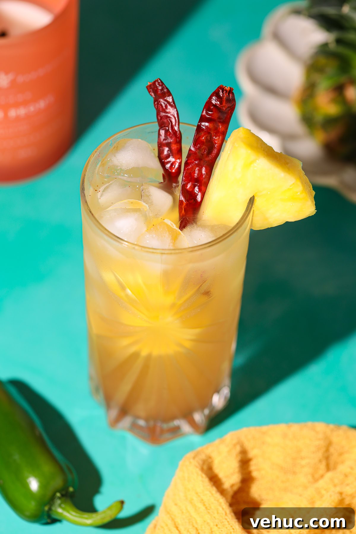 Spicy Pineapple Lemonade Recipe: Tangy Pineapple Citrus Cooler 5 spicy pineapple lemonade in a glass on a table with a pineapple in the background.