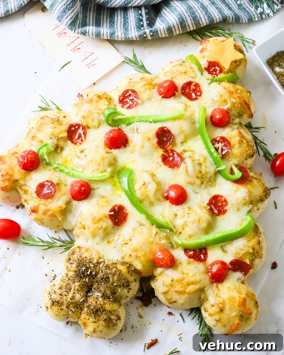 27 Festive Christmas Finger Food Appetizers for Holiday Parties 3 A Christmas tree pizza with peppers and tomatoes as ornaments.