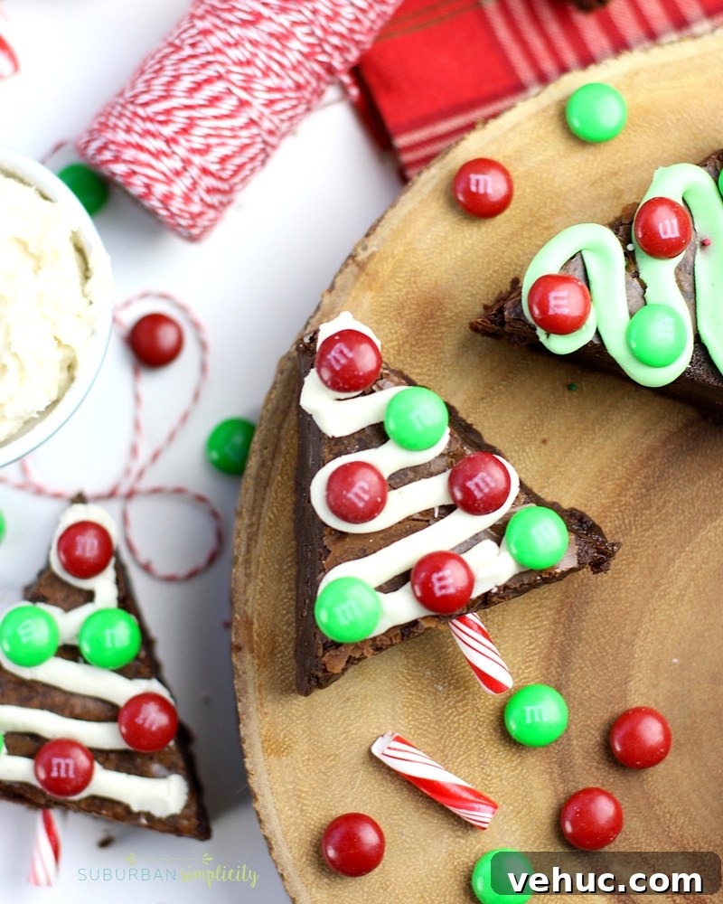 27 Festive Christmas Finger Food Appetizers for Holiday Parties 25 Brownies cut in the shape of Christmas trees with ribbons of frosting and M&M ornaments.