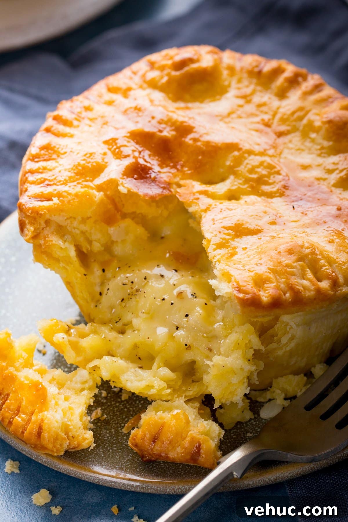 Chip Shop Style Individual Cheese and Onion Pies 2 Close up of a cheese and onion pie on a plate with a forkful taken out.