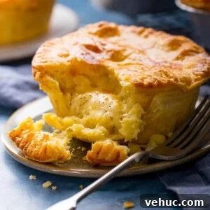 Chip Shop Style Individual Cheese and Onion Pies 9 Square image of a small cheese and onion pie on a plate with a piece taken out.