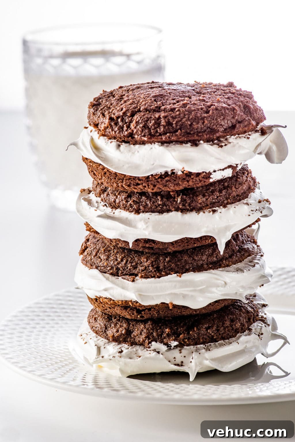 Keto Whoopie Pies with Marshmallow Filling — Low-Carb Gluten-Free 2 Stacked chocolate whoopie pies stuffed with marshmallow fluff on a white plate
