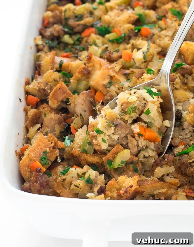 Easy Sausage Stuffing | chefsavvy.com stuffing in baking dish with fresh herbs for garnish