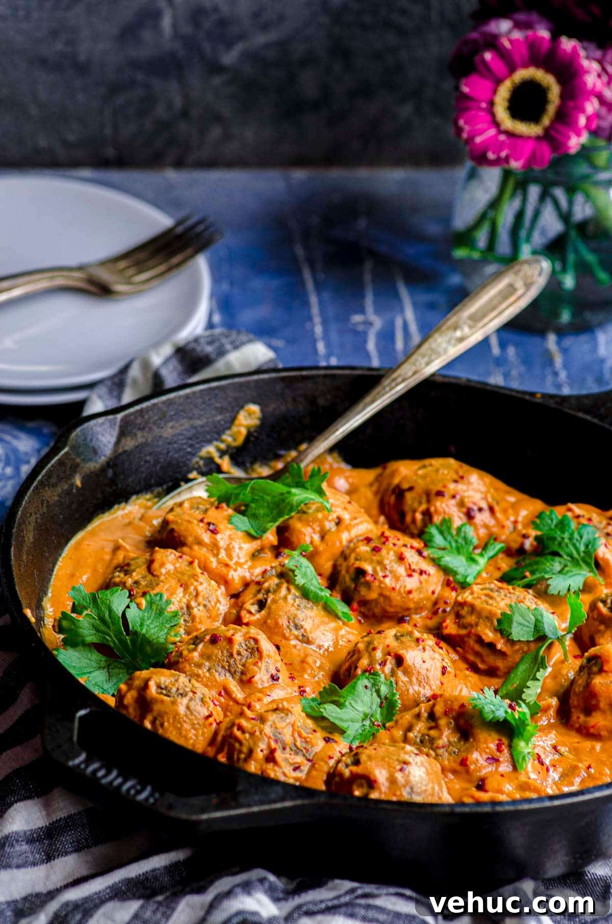 Vegan Meatballs in Savory Peanut Pumpkin Sauce 2 A slanted view of a cast iron skillet with veggie meatballs and pumpkin sauce