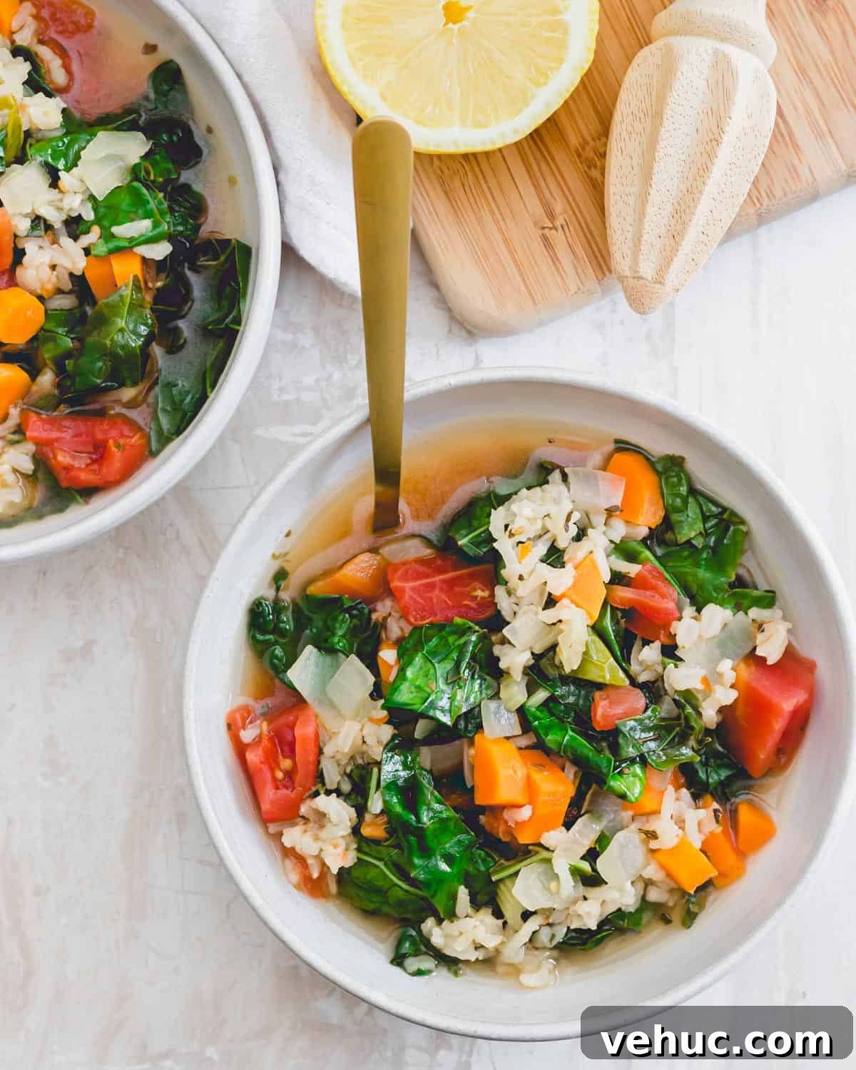 Simple Tuscan kale soup with carrots, onions, celery, diced tomatoes and brown rice in a bowl with a spoon. Simple Tuscan kale soup with carrots, onions, celery, diced tomatoes and brown rice in a bowl with a spoon.