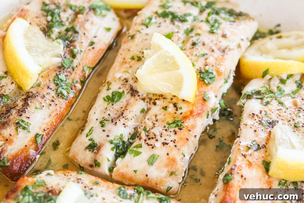 up close shot of mahi mahi topped with lemon in a skillet