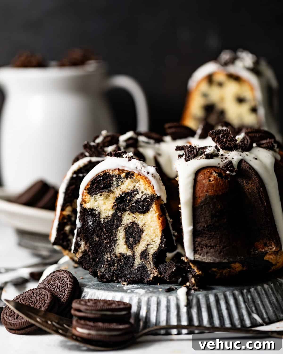Decadent Oreo Pound Cake Recipe: Moist Cookies and Cream Loaf 2 oreo pound cake on a serving plate with a slice cut out of the cake showing the marbled oreo pattern.