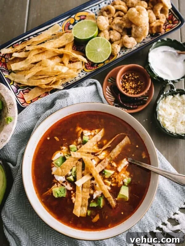 Authentic Cochinita Pibil Tacos Recipe — Yucatan Slow-Roasted Pork 11 chicken tortilla soup in a white bowl next to a platter of assorted toppings