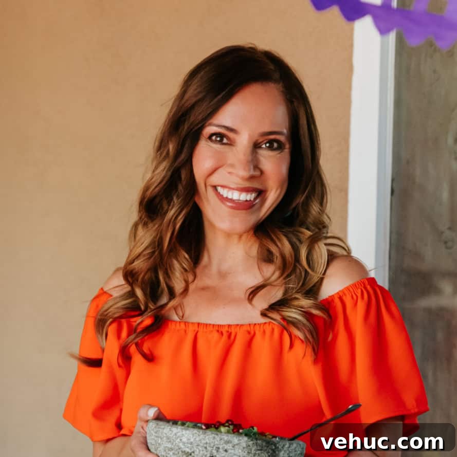 Authentic Cochinita Pibil Tacos Recipe — Yucatan Slow-Roasted Pork 3 Yvette Marquez muy bueno Mexican food blogger in an orange dress holding a molcajete.
