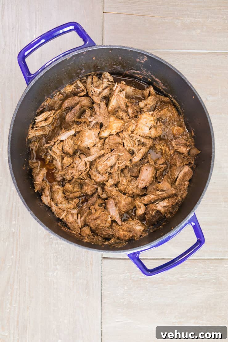 Authentic Cochinita Pibil Tacos Recipe — Yucatan Slow-Roasted Pork 6 Shredded Cochinita Pibil in a cast iron dutch oven.