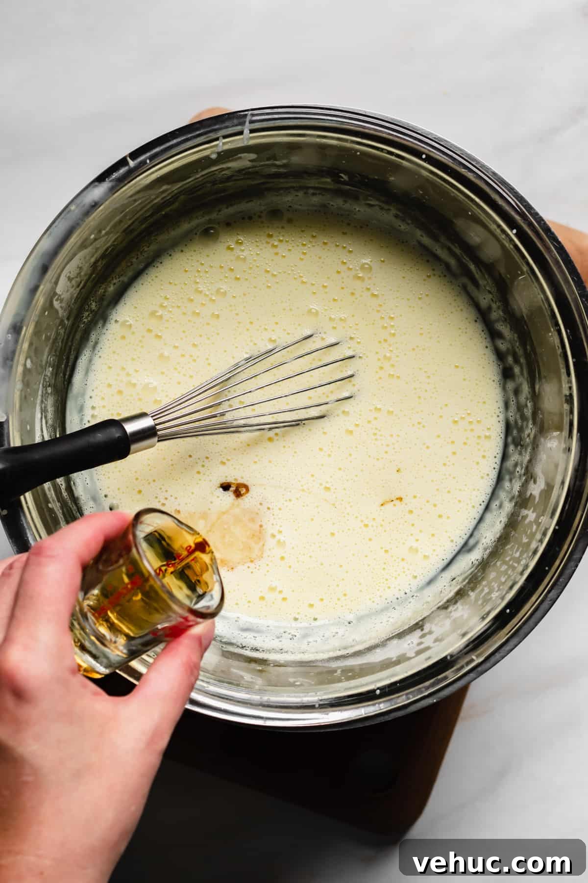 Pecan Bread Pudding with Creamy Vanilla Sauce 10 Bourbon being poured into vanilla custard sauce.