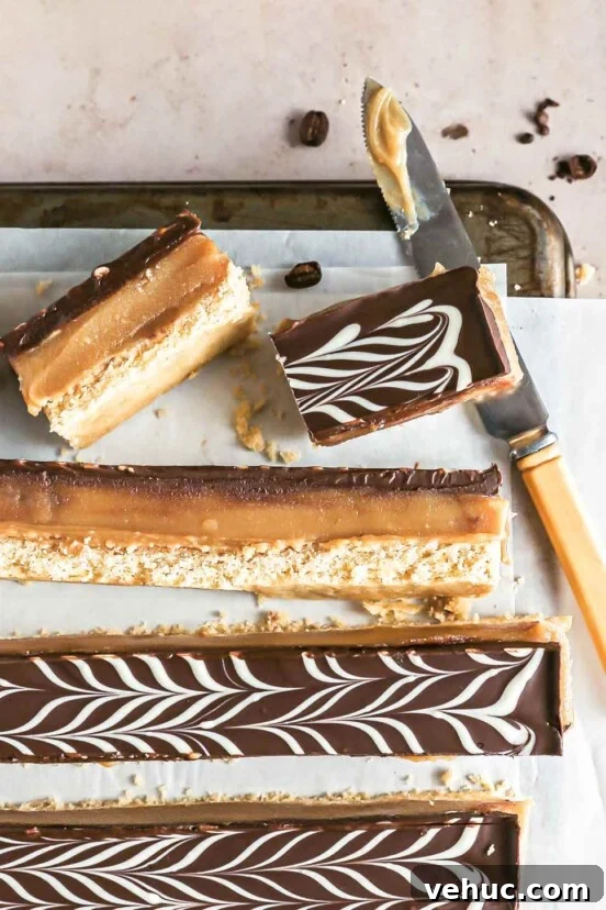 Classic Italian Rainbow Cookies Recipe You’ll Love 5 Espresso millionaire shortbread bars cut into long strips on a sheet of parchment paper on a cookies rack with a knife.