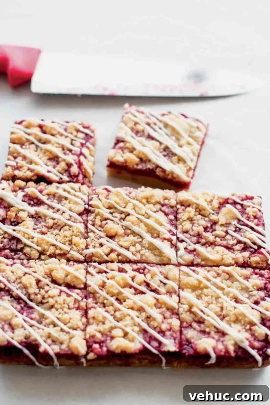 Classic Italian Rainbow Cookies Recipe You’ll Love 6 A batch of raspberry Linzer bars cut into nine squares, with one square missing and a knife in the background.