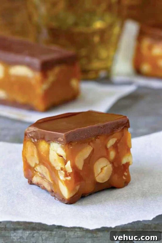 Classic Italian Rainbow Cookies Recipe You’ll Love 8 A square piece of homemade snickers bar on a piece of parchment.
