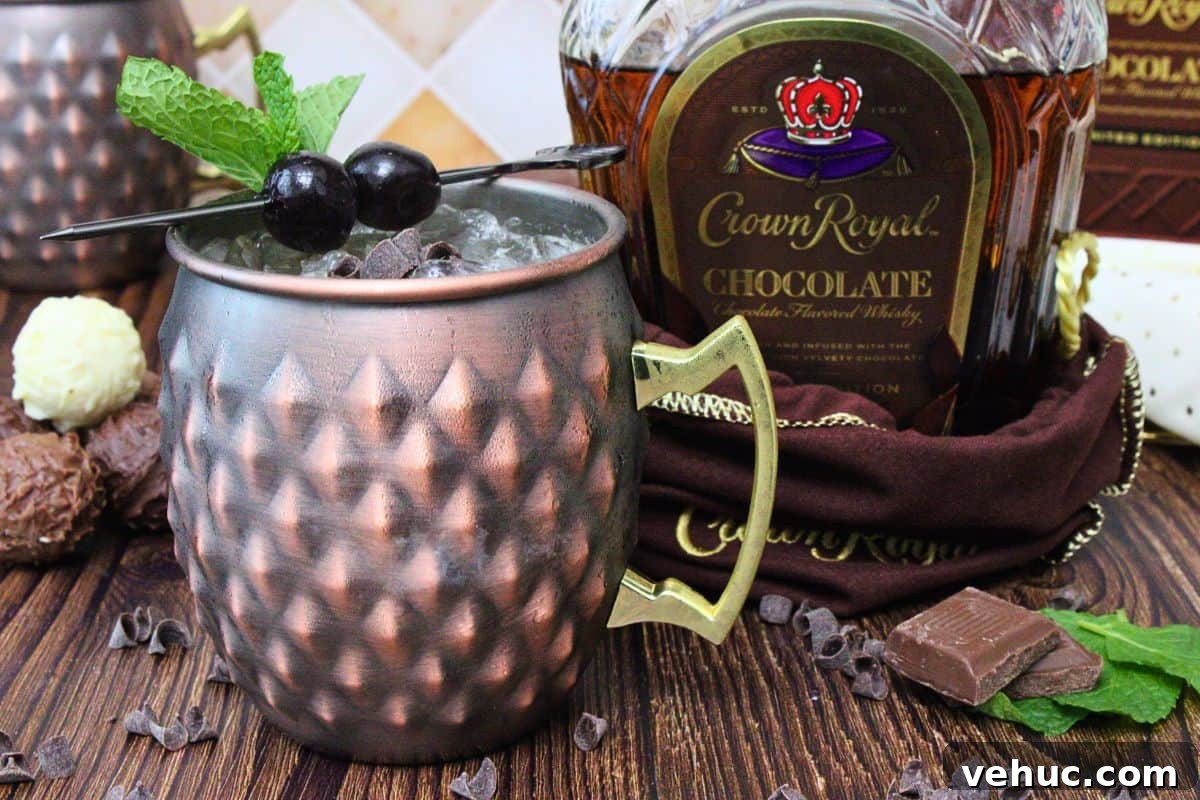 12 Irresistible Chocolate Crown Royal Cocktails to Try Tonight 12 chocolate mule in a copper mug with a cherry skewer next to chocolate crown royal bottle