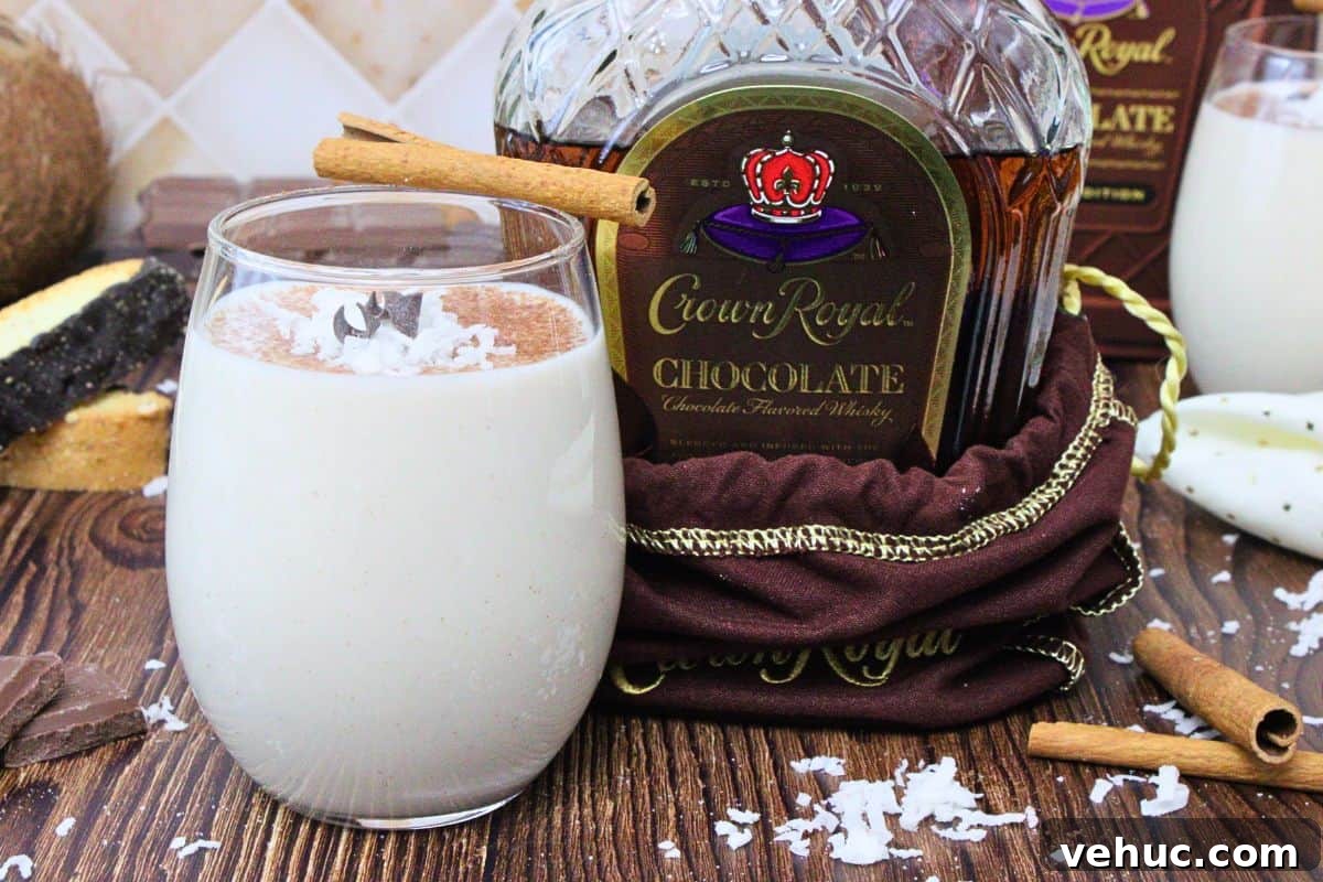 12 Irresistible Chocolate Crown Royal Cocktails to Try Tonight 13 chocolate coquito garnished with cinnamon stick and chocolate curls next to chocolate crown royal bottle